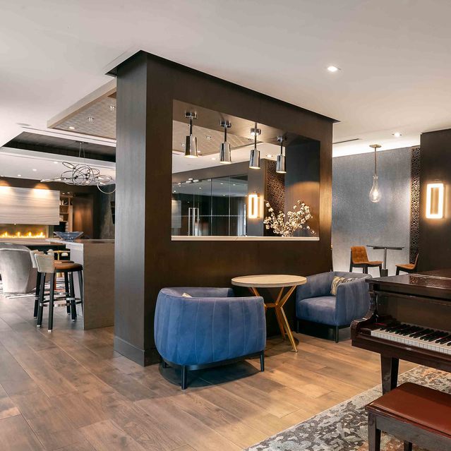 Instrata Pentagon City - Modern Lounge Area with Coffee Tables, a Grand Piano and a Fireplace