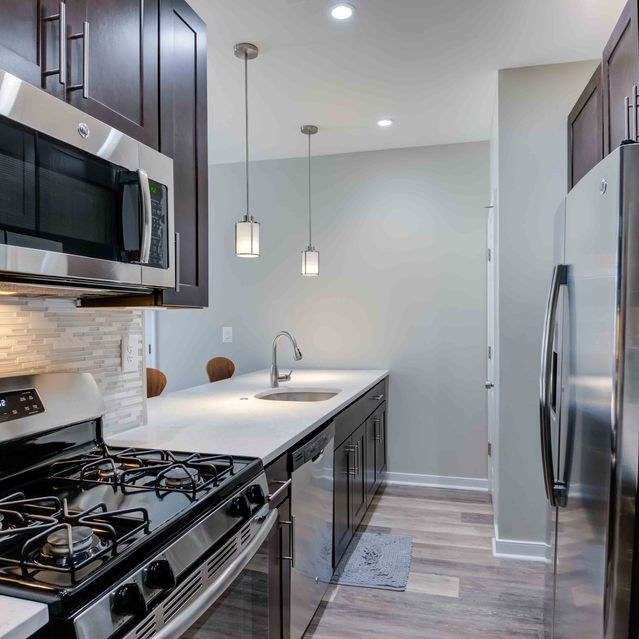 Instrata Pentagon City - Fully-Equipped Kitchen with Stainless Steel Appliances and Dark Wood Cabinetry