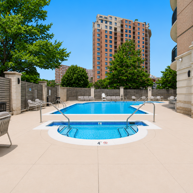 Instrata Pentagon City - Outdoor Swimming Pool and Hot Tub Surrounded By Lounge Chairs, Trees, and Apartment Buildings